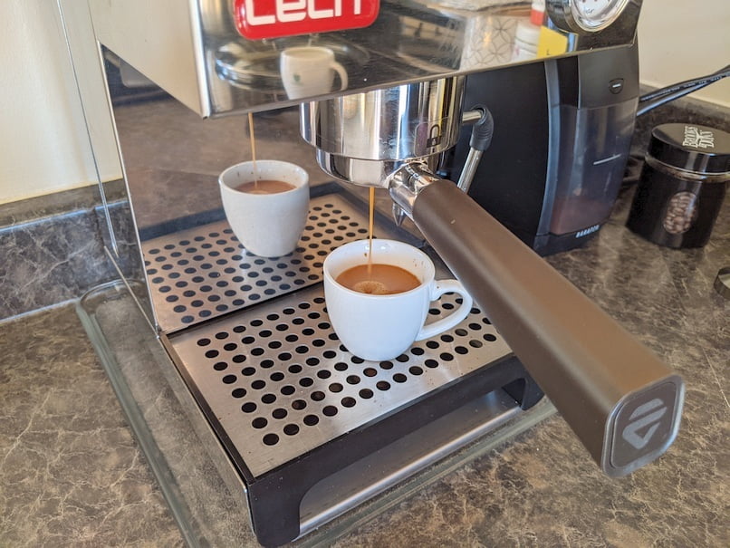 Espresso shot ready to be stopped. The demitasse is almost full.