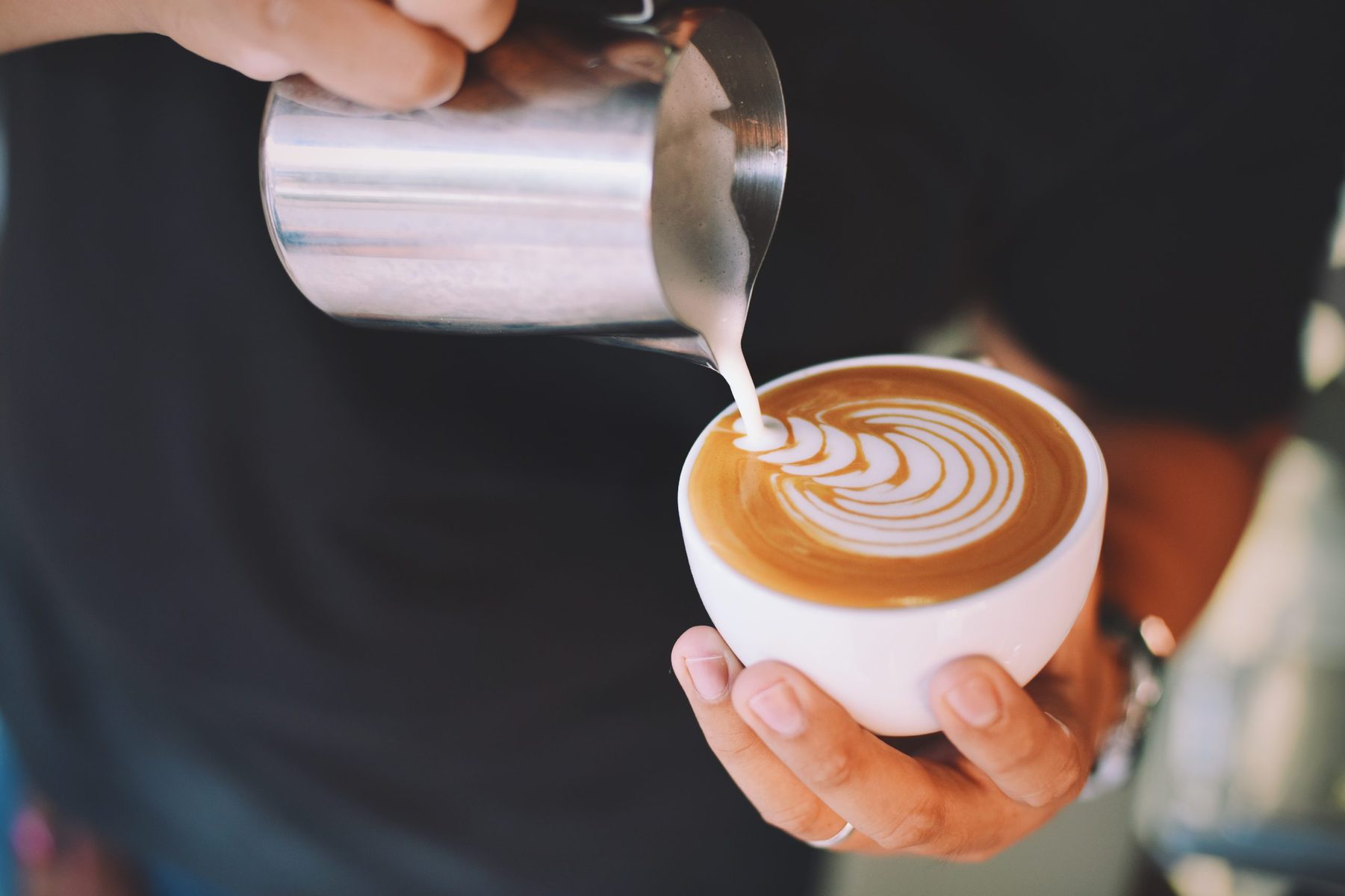 barista creating latte art in a latte cup