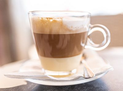 cortado leche y leche in a glass cup