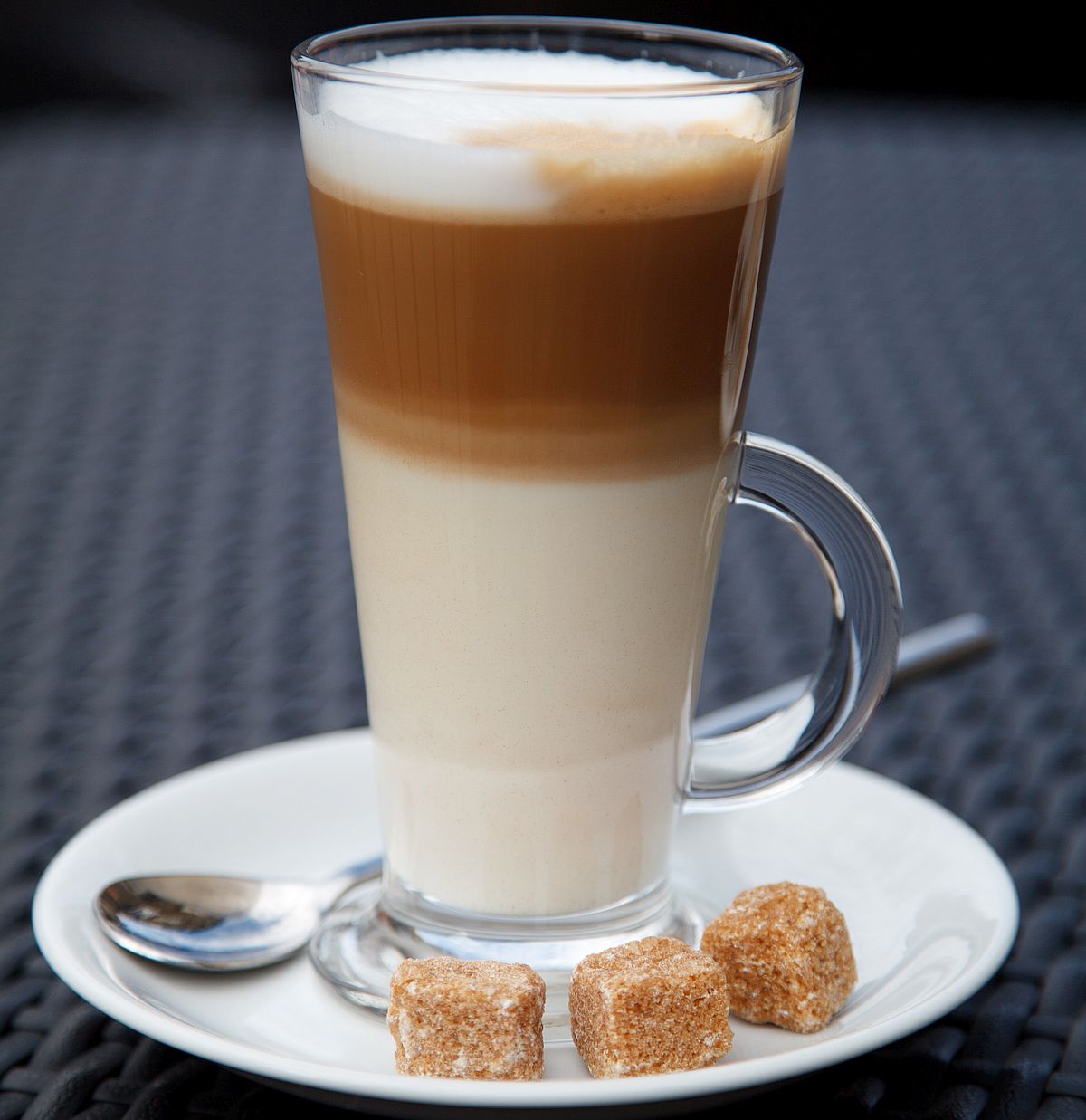 latte macchiato in a tall cup on a saucer