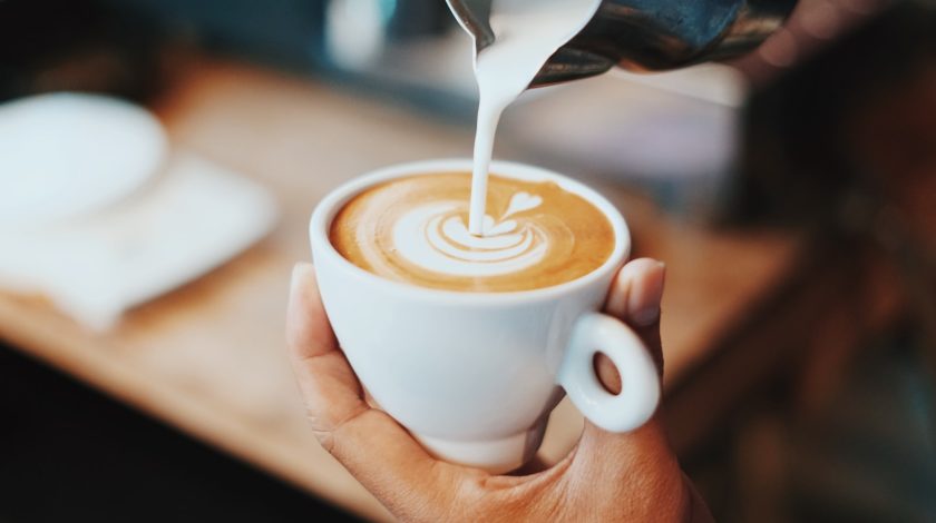 Pouring latte art in latte mug