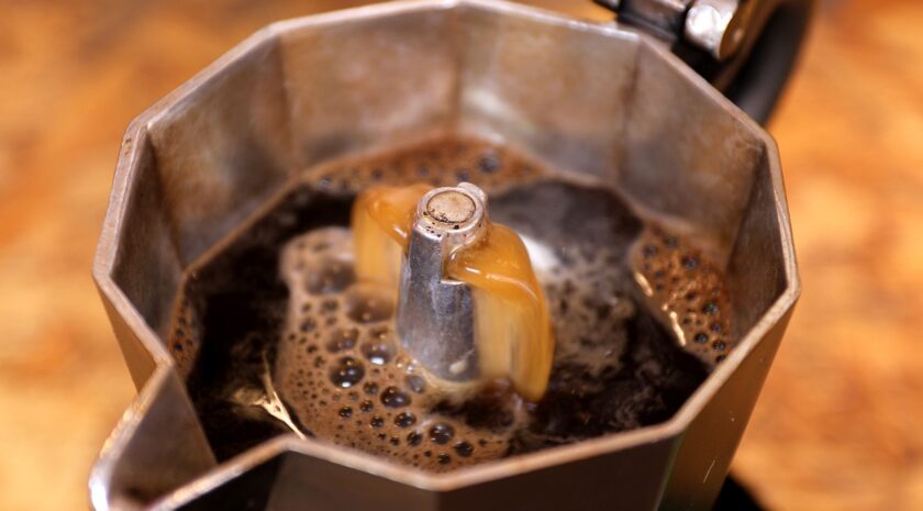 closeup of frothy freshly percolated espresso coffee in moka esp