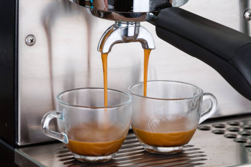 Espresso pouring into two clear cups.