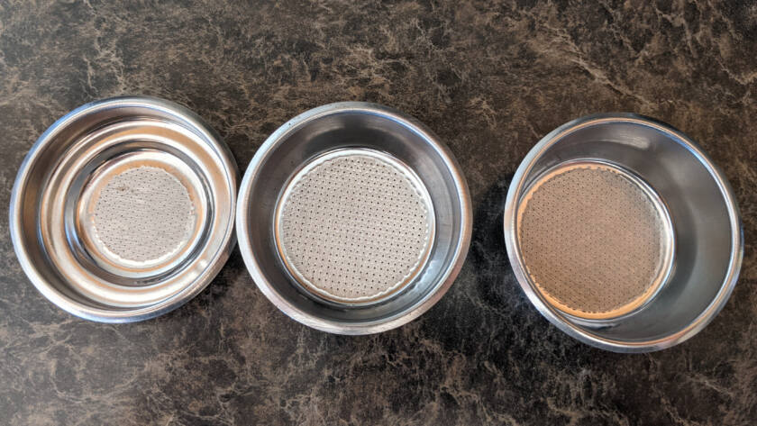 Three metal spice shakers on countertop.